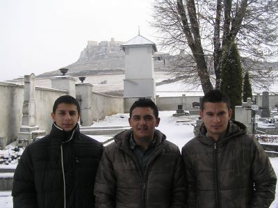 Tre romska killar i Spišské Podhradie; i bakgrunden Spišský hrad.